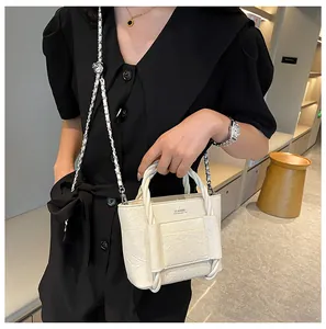Detail of off-white pleated leather bucket bag with braided handle and chain strap
