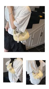 Detail of pale yellow glossy pleated handbag with lace bow and pearl decoration