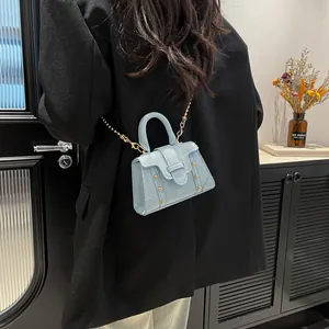 Minimalistische hellblaue quadratische Handtasche mit Nieten und Kette im stilvollen Look