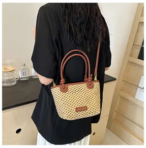 Close-up of beige woven bucket bag featuring brown leather straps and knot details