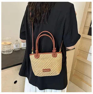 Straw hollowed-out bucket bag featuring woven mesh detail and brown leather handle