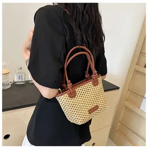 Close-up of woven bucket bag with honeycomb texture and elegant leather handles