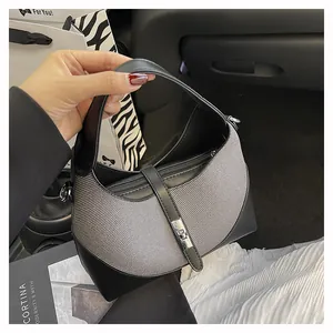 Detail of grey fabric and black leather hobo bag with silver metallic twist lock closure
