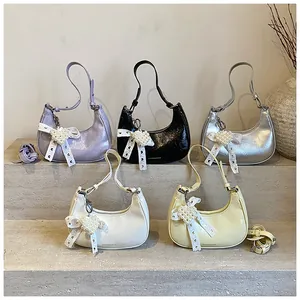 Detailed display of semi-circle crossbody bags in five colors with pearl heart pendants