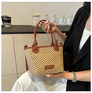 Close-up of woven bucket bag with leather handle and fashion brand patch on front