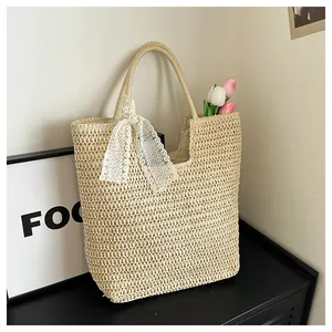 Detail of hand-woven straw tote bag with elegant white lace ribbon and floral accents