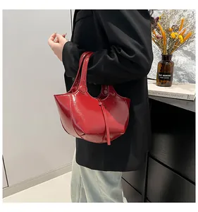 Detail der roten Lackleder-Eimertasche mit strukturierter Geometrie und Glanzeffekt