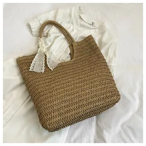 Close-up of hand-woven straw tote bag texture with white lace ribbon bow detail