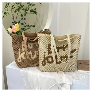 Close-up of hollow knit beach tote bags with Bon Jour embroidery and woven handles