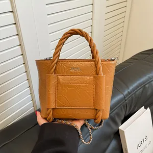 Brown pleated leather bucket bag with braided handle and silver chain strap