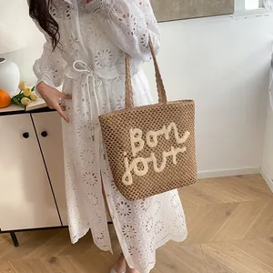 Brown woven straw tote bag with white Bonjour letter embroidery on the front side