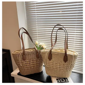 Close-up of woven straw tote bags with leather handles and drawstring lining detail
