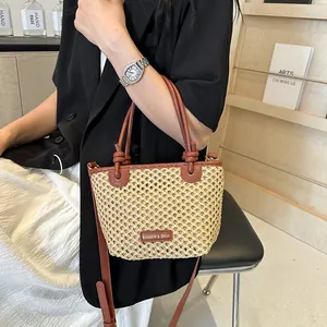 Chic beige straw bucket bag with brown leather handles and adjustable shoulder strap