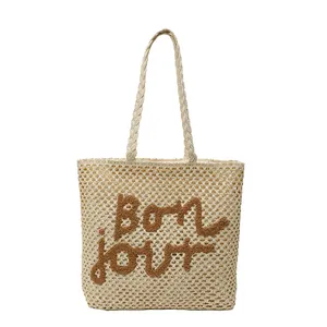 Hollow straw tote bag with bon jour lettering for beach vacation in cream white