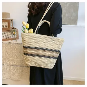 Détail macro du sac cabas en paille avec motif rayé et poignée circulaire