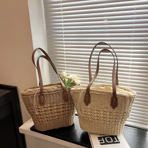 Handwoven straw tote bag with leather straps and drawstring lining in beige and brown