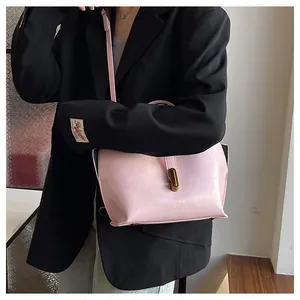 Detail of light pink leather tote bag with vintage gold metal buckle and stitch detail