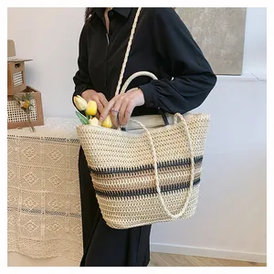Vue détaillée du sac cabas en paille tissée avec rayures noires et deux bandoulières