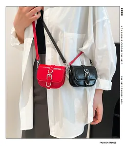 Detailsicht der roten Lackleder- und schwarzen Mini-Satteltaschen am Modell