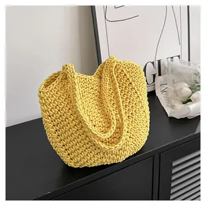 Gros plan détaillé du sac cabas jaune tissé main avec texture crochet sur surface sombre