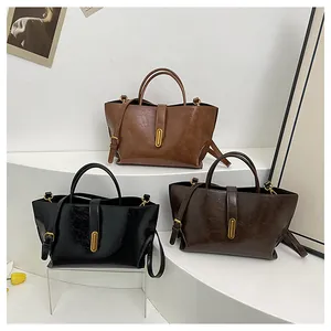Close-up of three vintage oil-wax leather handbags with golden vertical metal locks