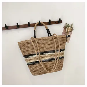 Détail du sac cabas en paille tressée avec rayures beige et noir et doubles anses