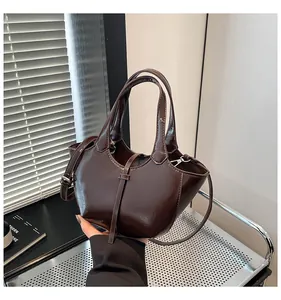 Details einer dunkelbraunen Beuteltasche mit Glanzeffekt und feinen Nähten