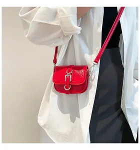 Detail der roten Lackleder-Satteltasche mit polierter Silberschnalle und glatter Textur