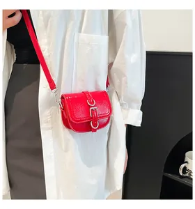 Detail der roten glänzenden Mini-Satteltasche mit Silberschnallen und Metallring