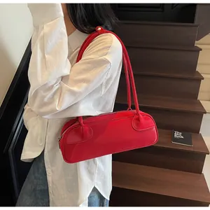 Sac baguette rouge en cuir porté par un mannequin au style rétro minimaliste chic