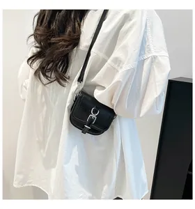 Detail einer schwarzen Satteltasche aus Leder mit silberner Schnalle und langem Schultergurt