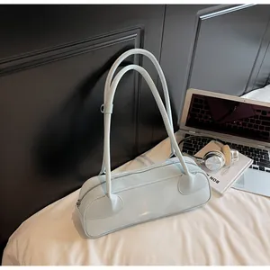 Détail du sac baguette en similicuir bleu clair brillant avec accessoires lifestyle