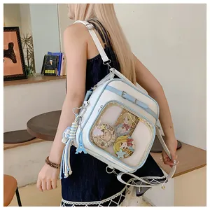 Detail of white and blue Ita bag with clear window showing anime badges and cards