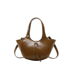 Minimalistische glänzende braune Beuteltasche mit schickem Halbmond-Design und Lederstruktur