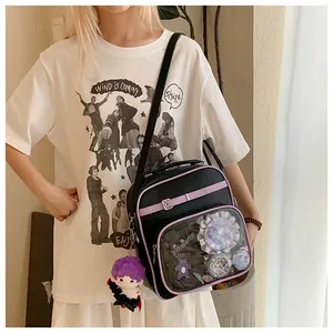 Detail of black ita bag with purple trim featuring a transparent window and plush charm