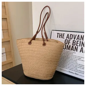 Détail du sac cabas en paille tissée avec bandoulière en cuir marron et texture