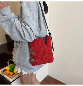 Detail of red hollow crochet tote bag featuring 3D floral texture and strawberry charms