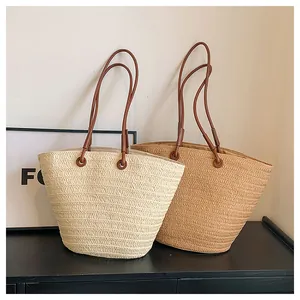 Vue détaillée des sacs cabas en paille tressée avec texture fine et anses en similicuir
