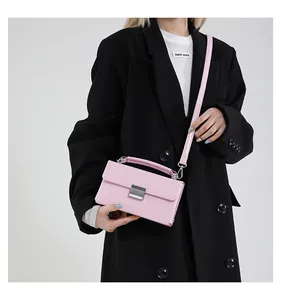 Detail der rosa Lederhandtasche mit silbernem Schloss und Zylindergriff am Modell