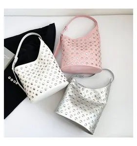 Trois sacs seau à clous en blanc, rose et argent avec bandoulières sur des costumes