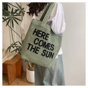Détail du sac cabas tissé avec inscription 'HERE COMES THE SUN' noire et style naturel