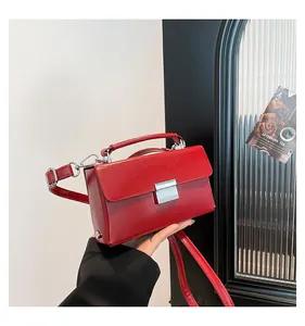 Detail der leuchtend roten Lackleder-Handtasche mit silberner Schnalle und Tragegriff