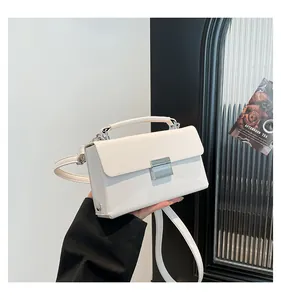 Detail der minimalistischen cremefarbenen Ledertasche mit Metallschnalle und Schultergurt