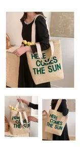 Detail of woven beach tote featuring Here Comes The Sun green lettering and wide strap