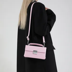 Rosa minimalistische Umhängetasche mit silberner Schnalle, getragen von einem Model