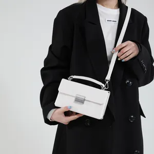 Elegante weiße Ketten-Schultertasche mit silberner Schnalle auf schwarzem Blazer
