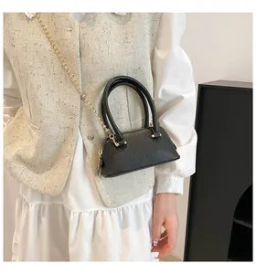 Detail of black lychee grain leather mini bag with gold bead chain strap and handles