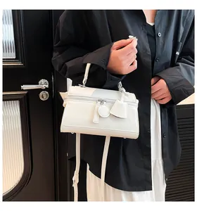 Minimalistische weiße Saffiano-Umhängetasche getragen von einem Modell zur Ansicht