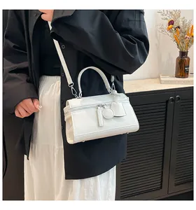 Nahaufnahme der weißen Lederhandtasche mit Silberbeschlägen und abnehmbarem Anhänger