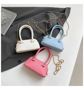 Detailed overhead view of mini seashell bags in white, blue, and pink with bead chains